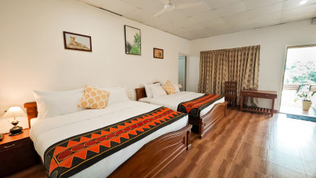 twin beds and wooden flooring in executive room with a balcony3 - Ibex Stays & Trails, Valparai (Mistly)