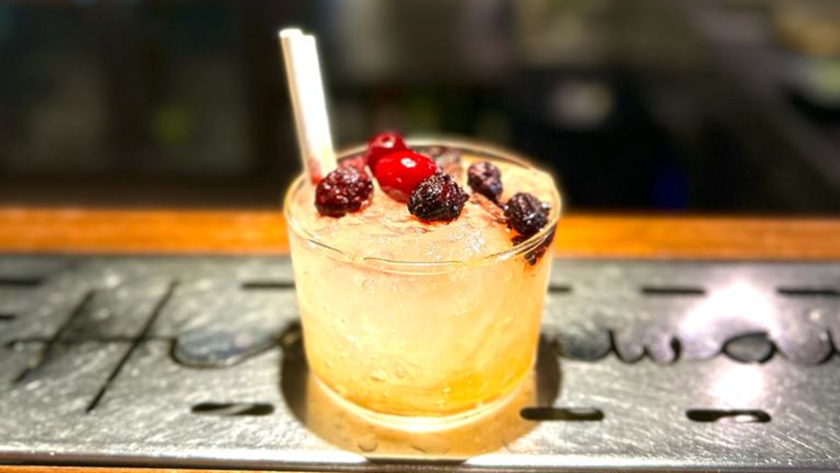 A delicious looking drink with dried fruits on top rest on the counter at Hideaway