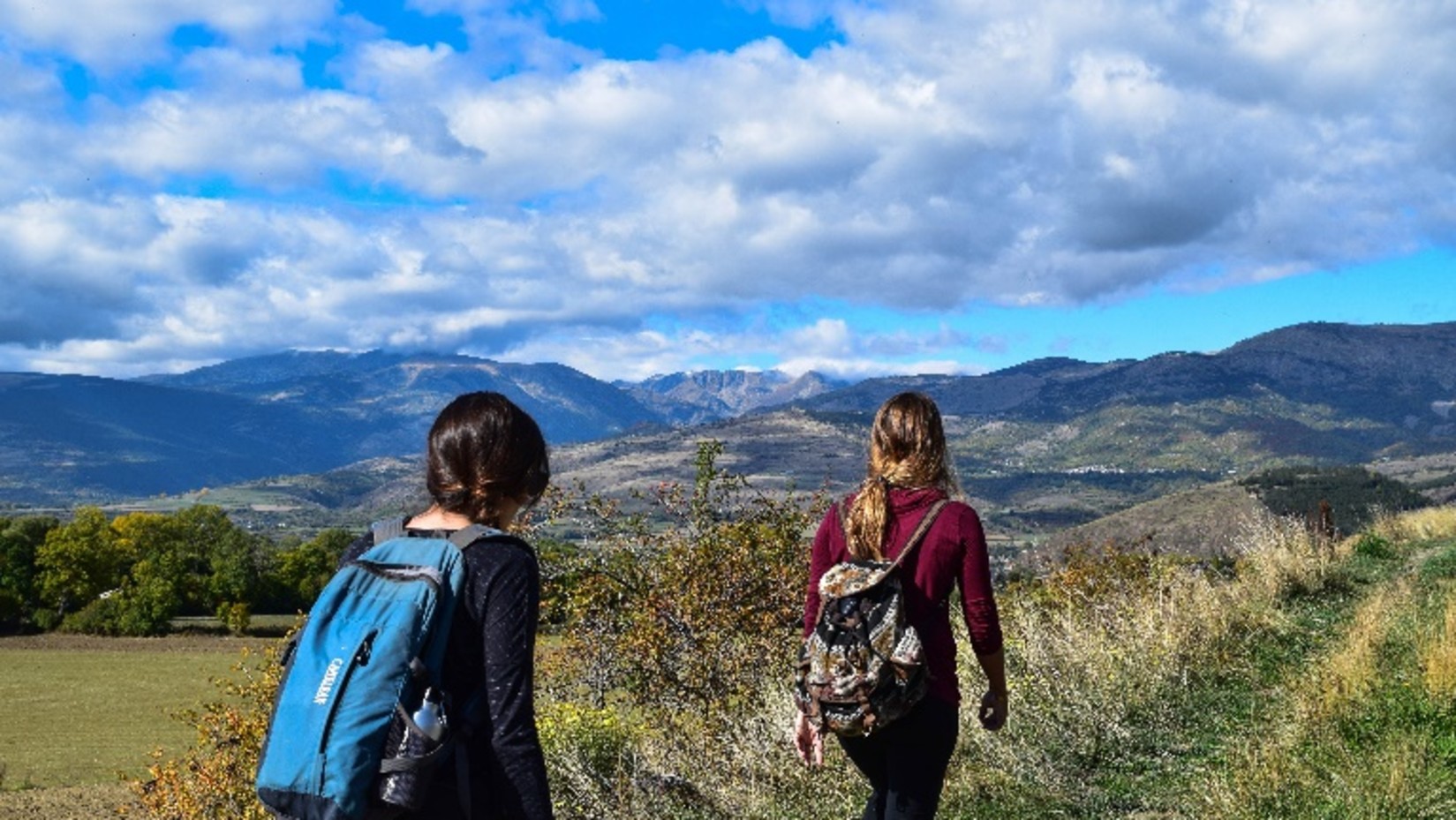 two women trekking on a hill