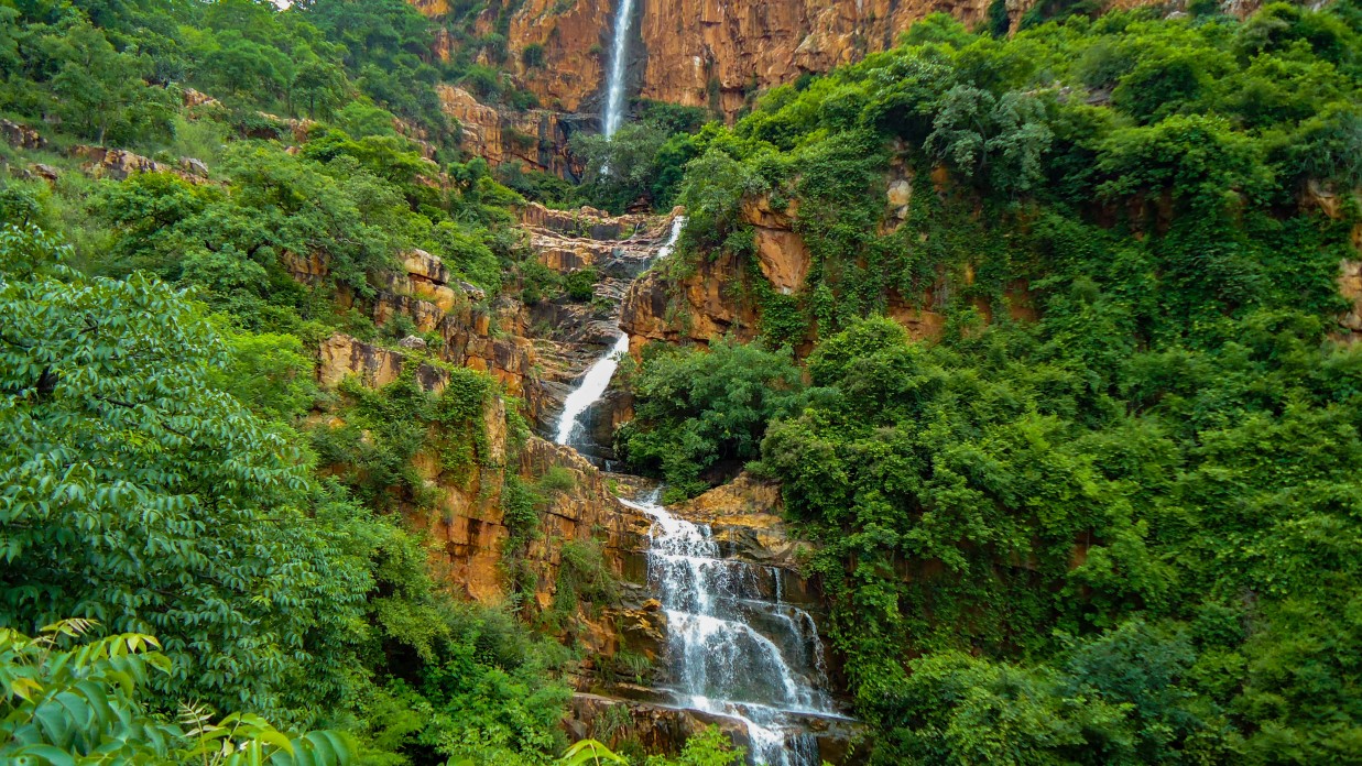 a waterfall in middle of a jungle