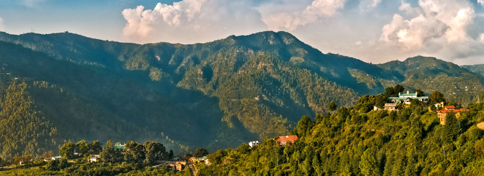 Scenic mountain view of lush green mountains with clouds in the background  captured during the day