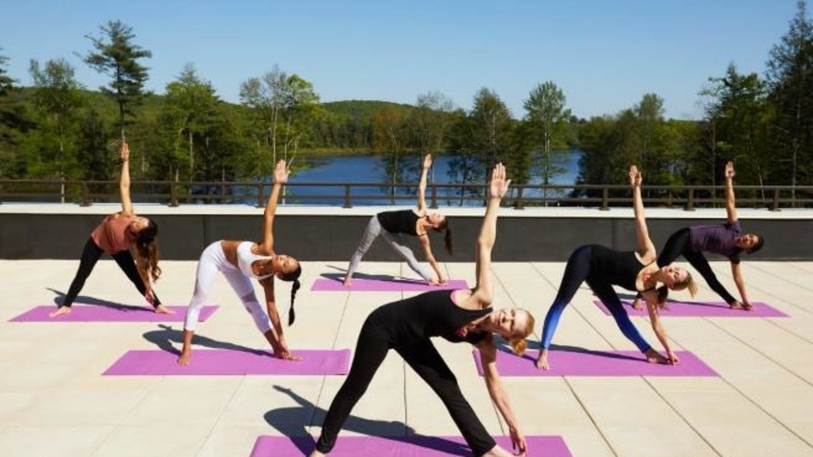 Yo1 Longevity and Health Resorts - Image of 5 women practicing yoga in an open space