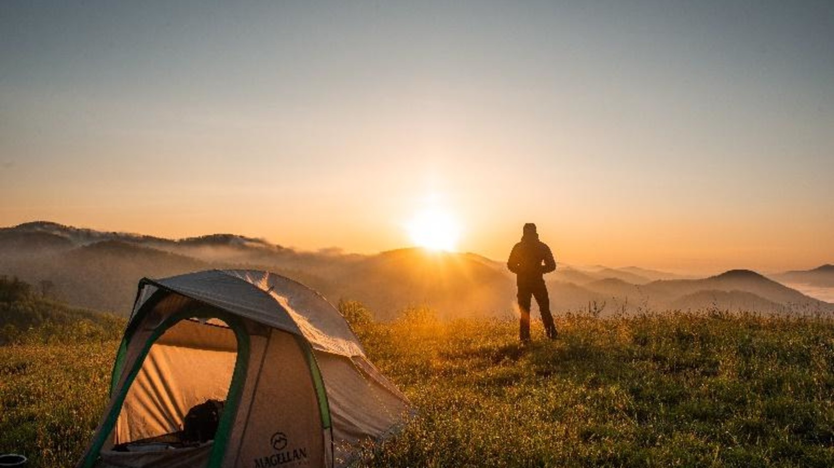 a man standing next to a tent