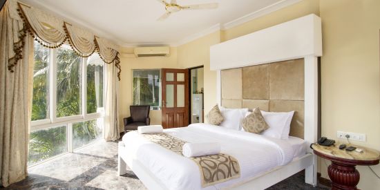 alt-text The luxurious Master Bedroom offers a large balcony with a great view - Stone Wood Riverfront Resort, Siolim