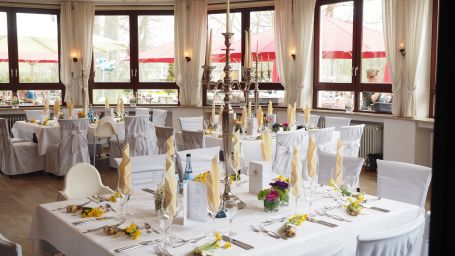 a banquet hall where tables and chairs are covered in white sheets