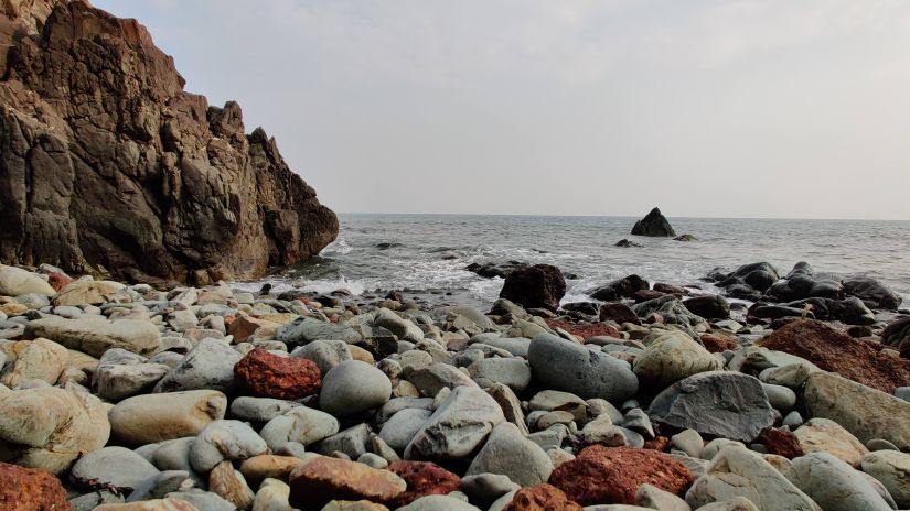 rocks and rocky hills on the side with blue sky in the background at Butterfly Beach in Goa