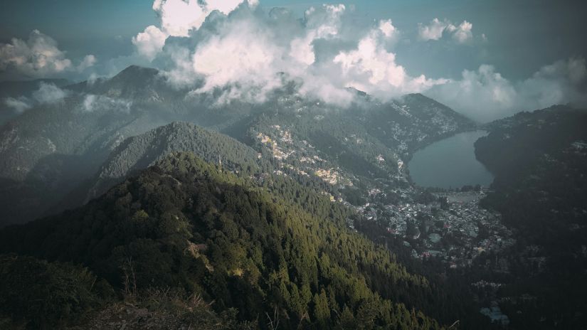 a view of mountains and white clouds next to them with blue sky in the background