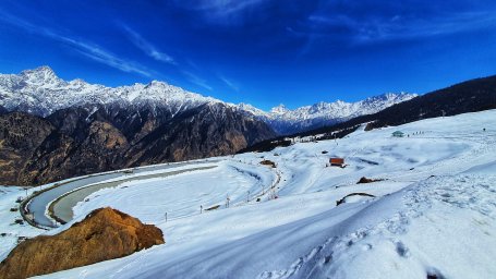 skiing in Auli amidst snow with backdrop of majestic mountains 