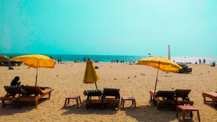 people relaxinng on sun loungers at a beach in goa