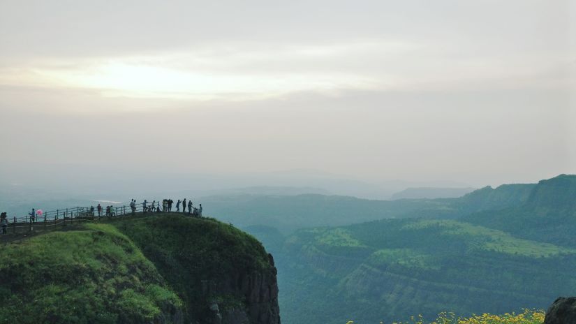 A group of people standing on top of a lush green hillside.