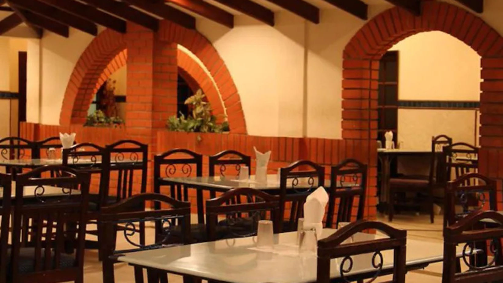 Side view of restaurant Mayura, which has multiple chairs and casual ambience - Hotel Ram International,  Pondicherry