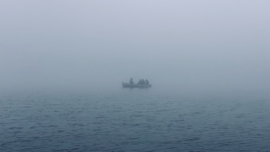 a boat at sea obscured by fog