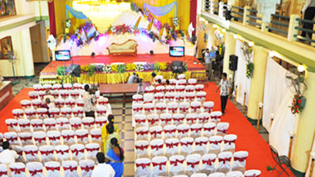 Hotel Yasodha Towers - interior view of the banquet hall featuring a stage and chairs placed in 13 columns split at the centre