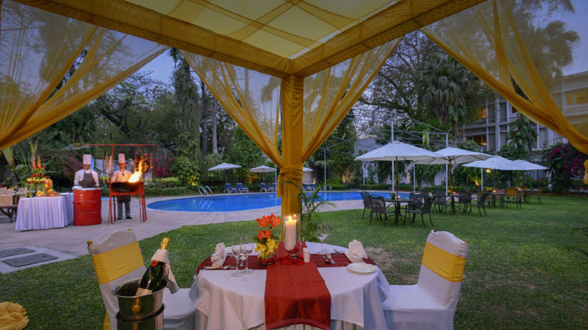 Clarks Varanasi - outdoor dining set up by the pool at nightttime 2