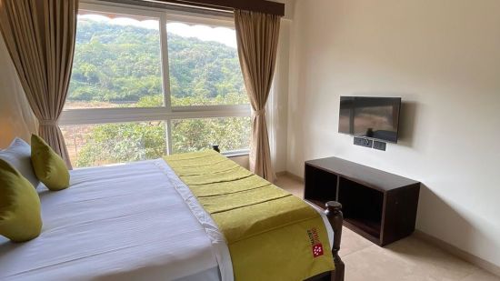 room in lonavala with bed and cupboard and forest view - Mastiff Grand La Villae Resort, Lonavala