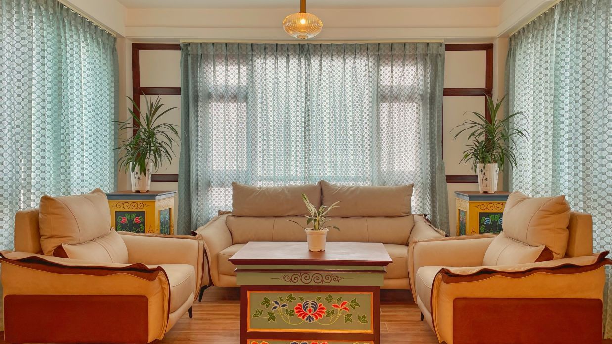 A living area featuring light brown sofas, a coffee table and plants - Voyage Glenz Resort