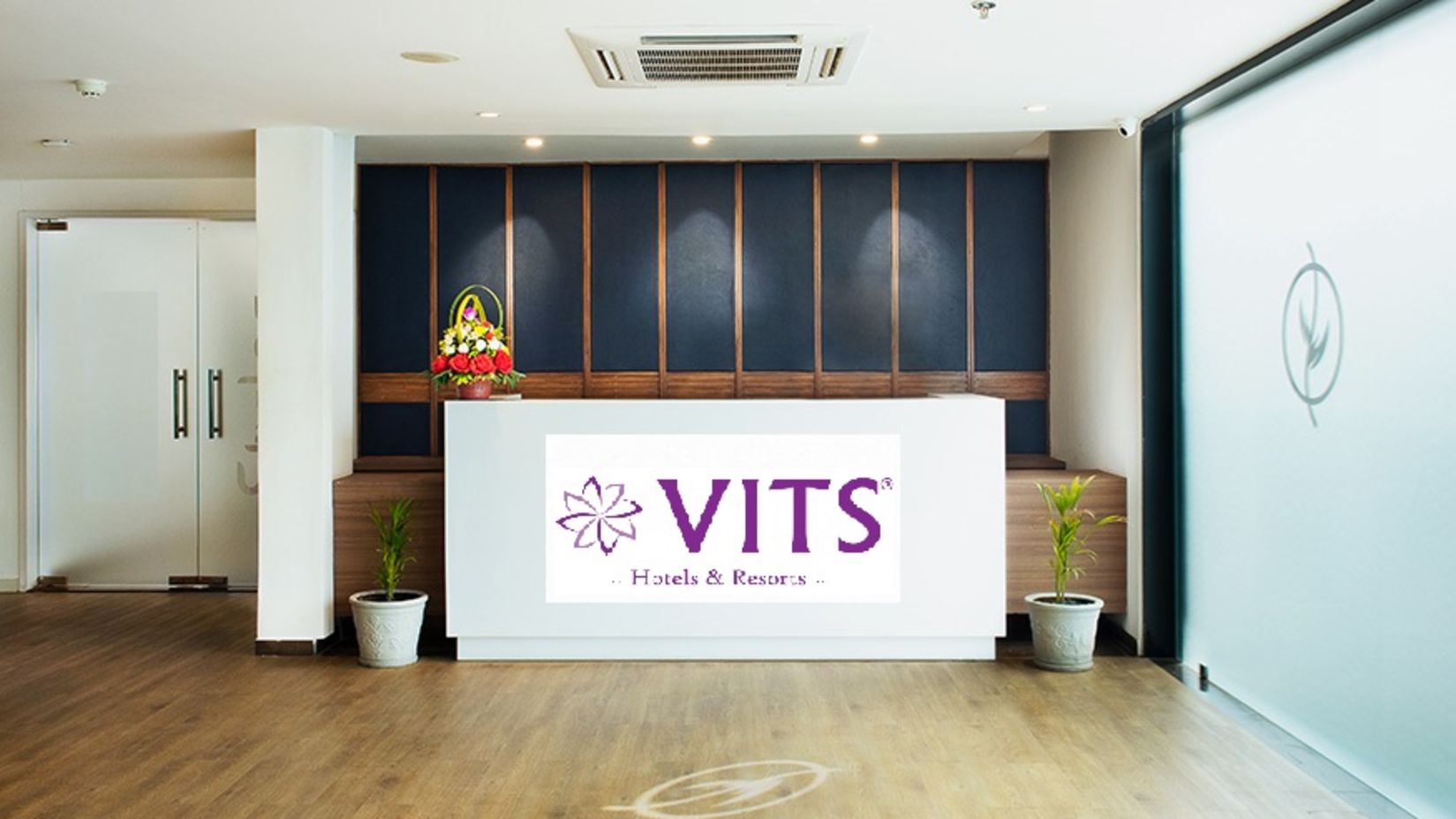 Reception area with a floor to ceiling glass next to it - VITS Rajkot