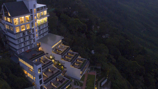 An aerial view of the grand facade of Fragrant Nature Munnar at night