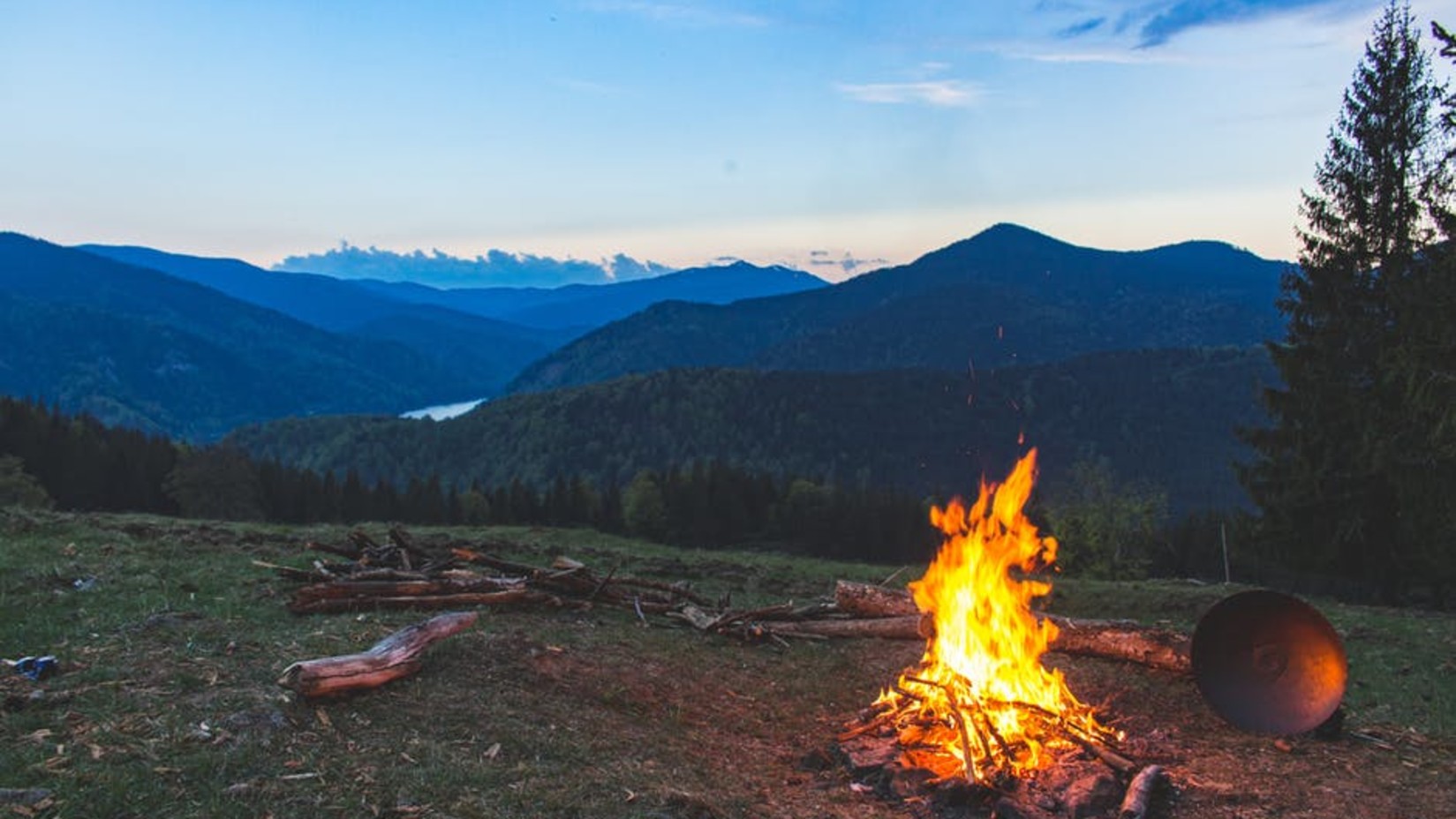 Campfire image in the middle of the mountain with a pretty hill view after golden hours.