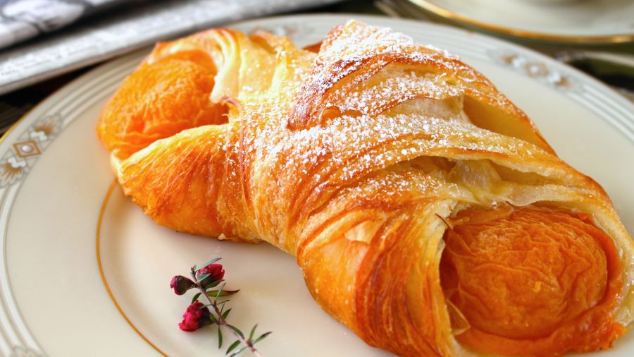 croissant with powered sugar kept on a plate