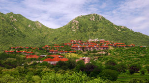 A wide and distant view of the resort with hills in the background - Ananta Udaipur