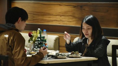 Two people sitting opposite to each other at a table and having food | Hotel City Inn, Varanasi