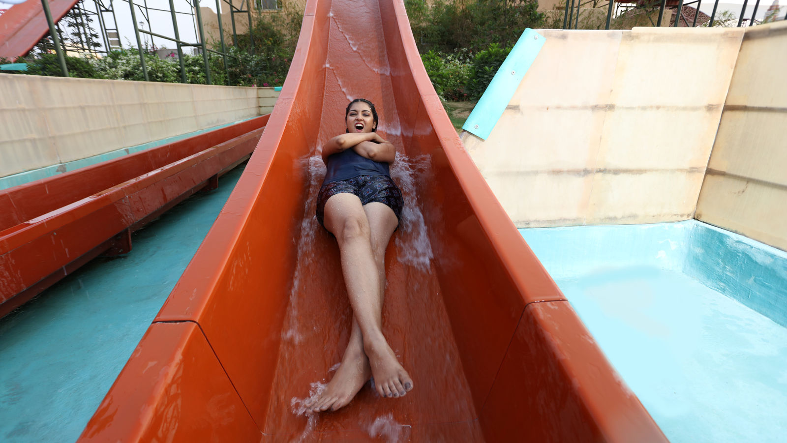 Woman sliding down a red water slide