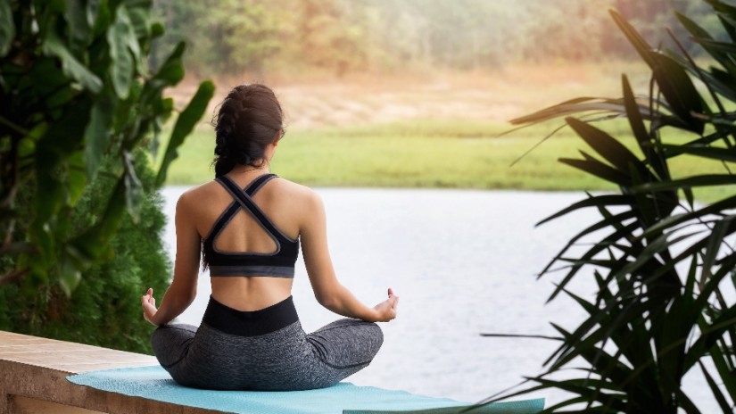 a girl doing yoga in front of a pool