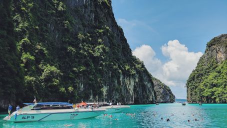 A boat travels across the Andaman sea and mountains are visible at the backdrop - Symphony Summer Sand Beach Resort and Spa