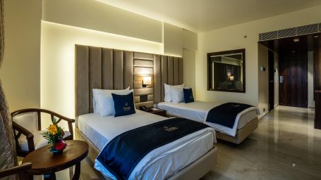 Side view of Deluxe Twin with bedside tables seating area with ample of space - Mastiff Grand - The Sia Palace Suites Banquets Khopoli