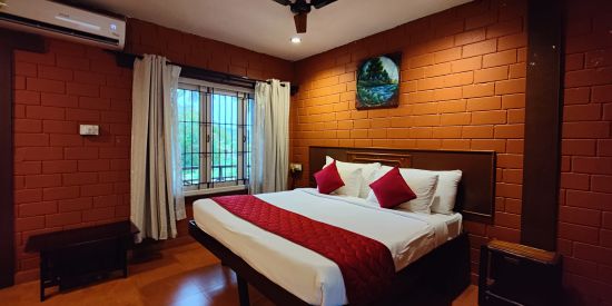 alt-text a double bed inside Executive Deluxe Room View at Ibex River Resort, Pollachi