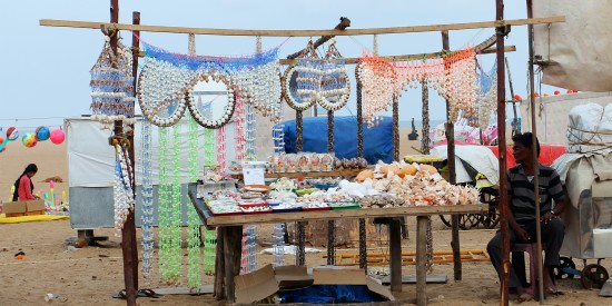 alt-text A stall selling items at a beach with blue sky in the background