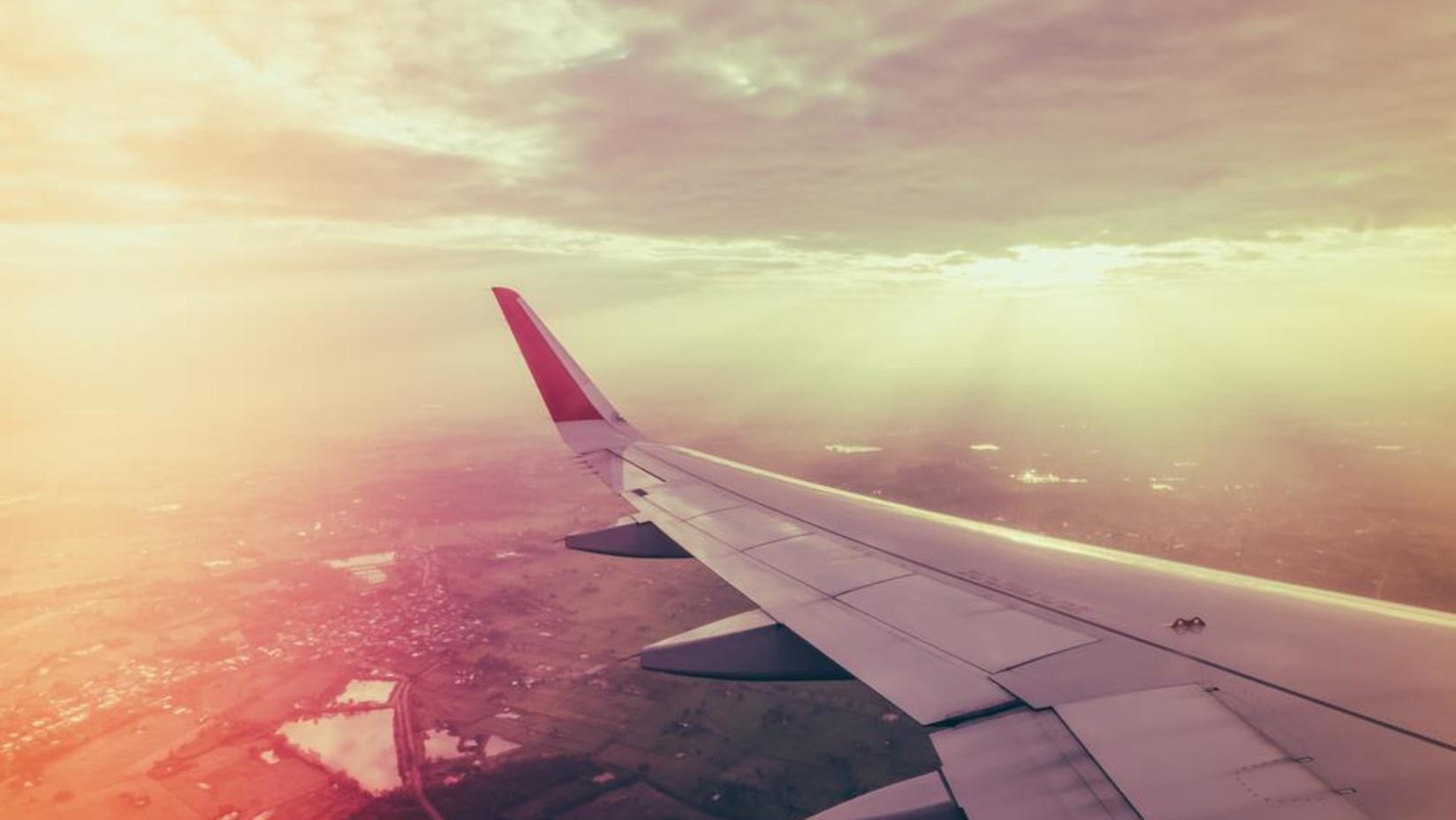 Aeroplane flying in the sky with the sun's rays showing from the clouds