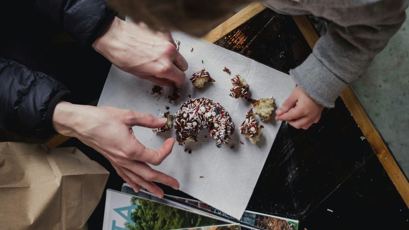 two people having their hands on a dessert kept on a table