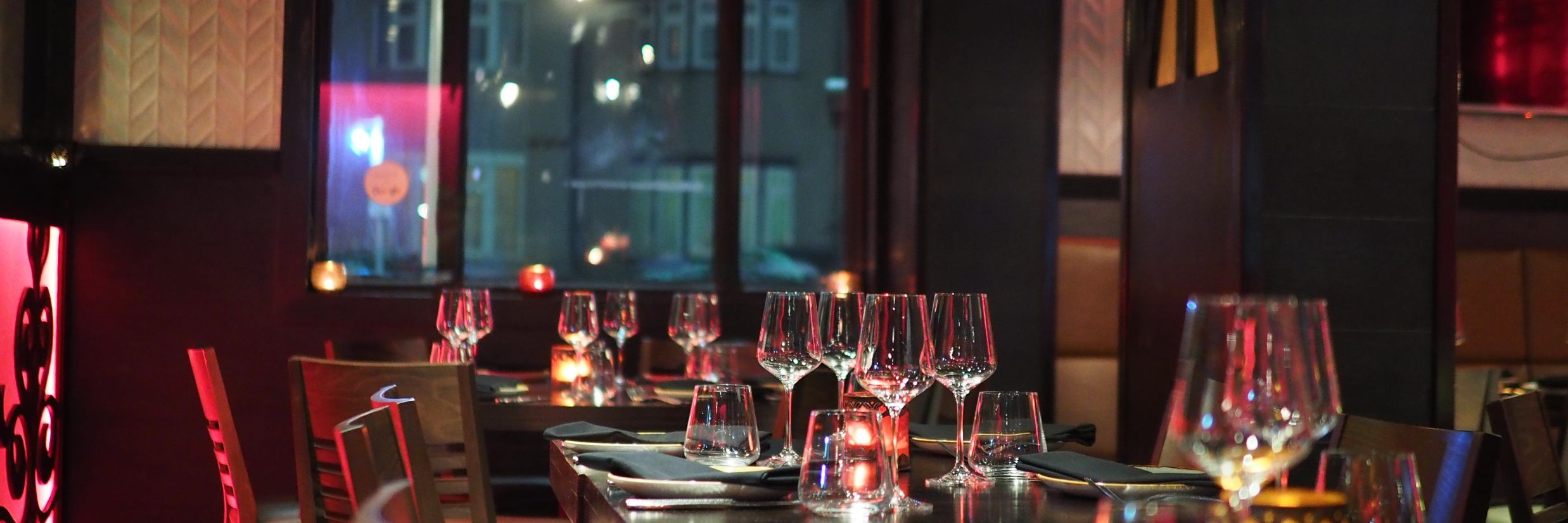 restaurant at night time with dim lighting and utensils decorated on the table