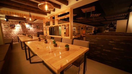 a table laid in chipotle restaurant with lamps hanging from the ceiling - Click Hotel Capital House, Patna