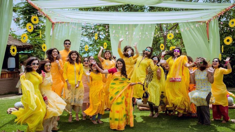 alt-text Women dressed in yellow celebrating gleefully