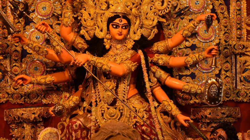 an image of devi durga defeating the demon inside a pandal during durga puja