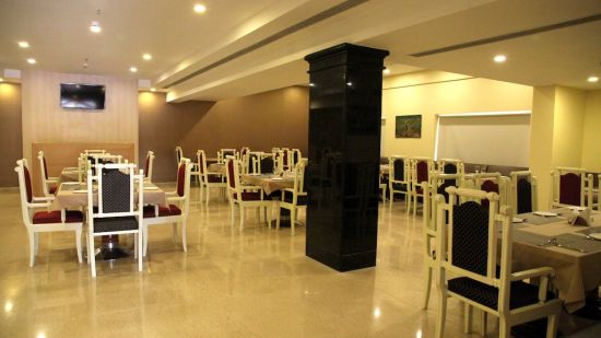 seating arrangements inside the Restaurant with lights on - Raj Park Hotel, Tirupati