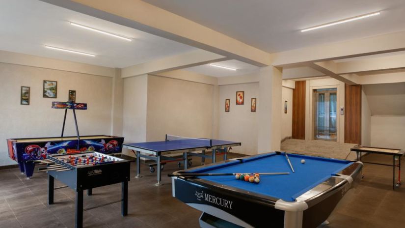 an indoor games room with a pool table and foosball board