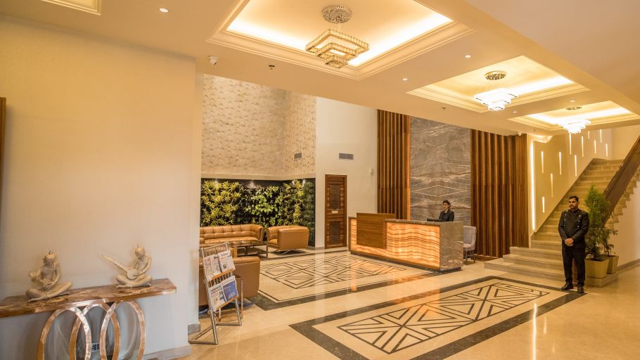 warmly lit interior of lobby at Ramada by Wyndham Kapurthala with a person standing in the reception area