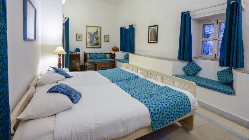 Hill Fort Kesroli 14th Century Alwar - interior view of the Mayur Mahal - Countryside View room with blue decor, air conditioner and king size bed 