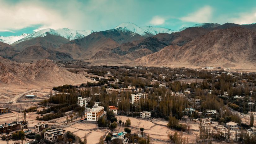 Brown mountains with with trees and small huts