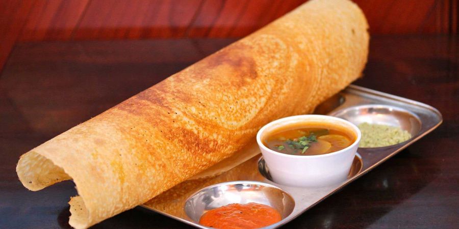 alt-text The south india dish dosa, sambar and chutney served on the plate.