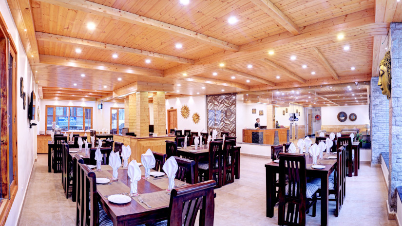 Image of the restaurant with tables and chairs with wooden ceiling at Summit Chandertal Regency Hotel & Spa 