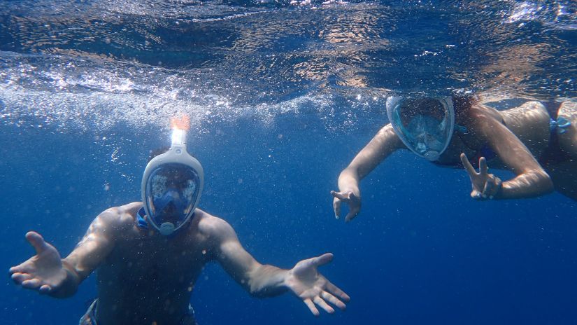 two people snorkelling and posing for a picture underwater