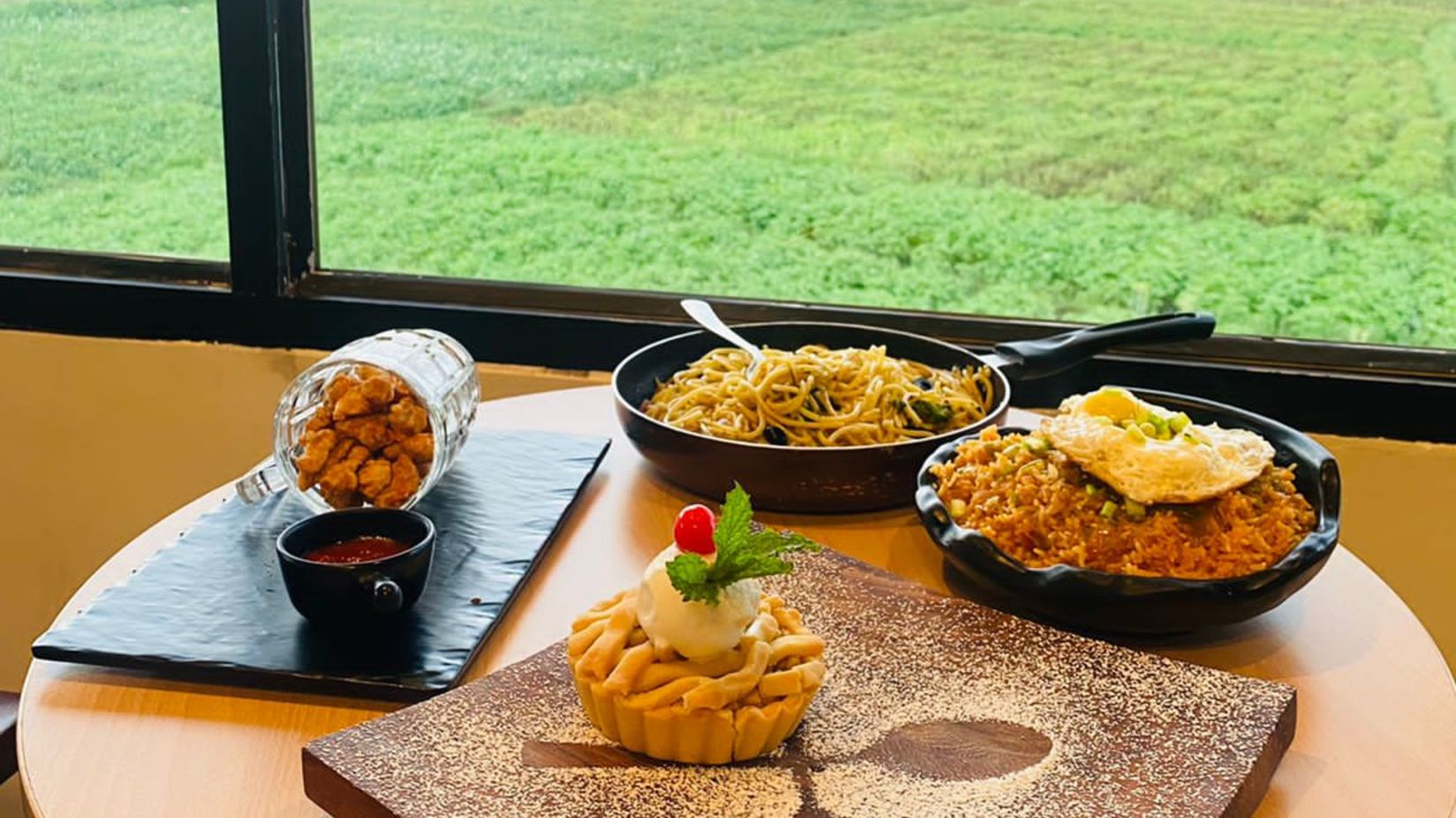 Delicious looking dishes on a table overlooking a scenic lawn