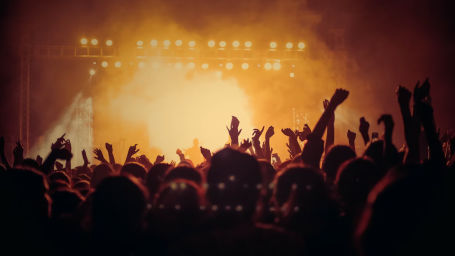 a crowd of people dancing to music at a party