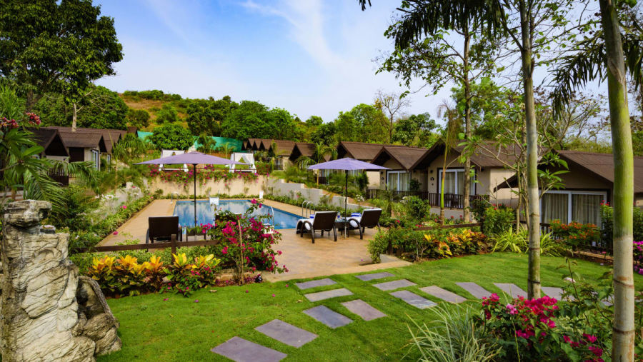 The garden with blooming flowers and the cottages at our resort in Mandrem 