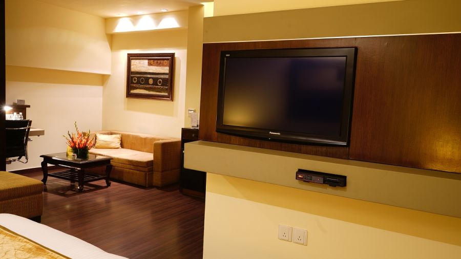 Club Premium Room decked with a television and a sofa at Shervani Nehru Place, New Delhi